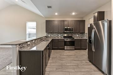 Humble house for rent - A kitchen with a refrigerator on the right side.