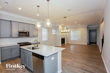 Westfield house for rent - an open kitchen and living room with white countertops and gray cabinets