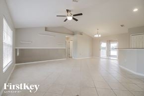 Lehigh Acres house for rent - an empty living room with a ceiling fan