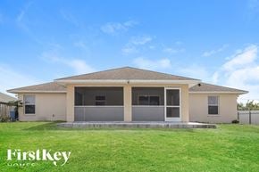 Lehigh Acres house for rent - a house with a grass yard and a porch