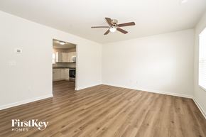 High Point house for rent - A spacious room with wooden flooring and a ceiling fan.