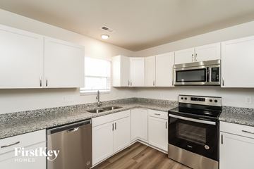 High Point house for rent - A kitchen with white cabinets and stainless steel appliances.