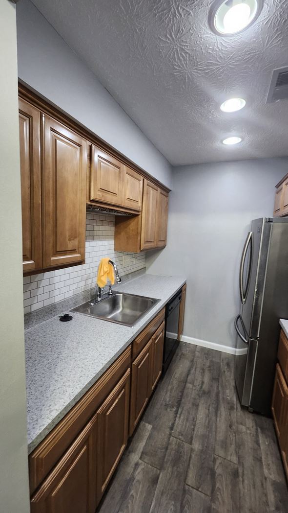 Cincinnati apartment for rent - A kitchen with wooden cabinets and a stainless steel refrigerator.