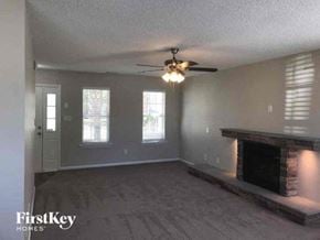 Charlotte house for rent - a living room with a fireplace and a ceiling fan