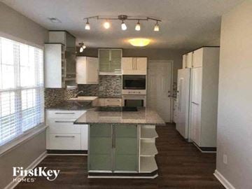 Charlotte house for rent - a kitchen with white cabinets and a counter top