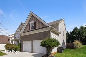 Charlotte house for rent - A two-story house with a garage and a tree in front.