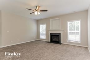 Charlotte house for rent - A spacious living room with a fireplace and a ceiling fan.