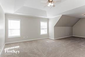 Charlotte house for rent - A spacious room with a ceiling fan and two windows.