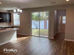 Jacksonville house for rent - an empty living room with a sliding glass door to a yard