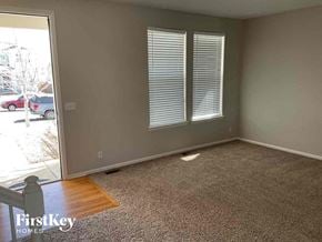 Thornton house for rent - an empty living room with a wooden floor and two windows