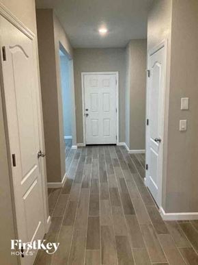 Jacksonville house for rent - A hallway with a white door and wooden floors.