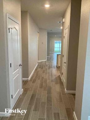 Jacksonville house for rent - A long hallway with tile flooring and white doors.