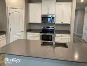 Jacksonville house for rent - A kitchen with a stove top oven and microwave built into the cabinetry.
