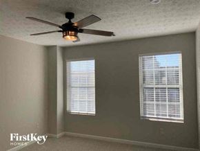 Mcdonough house for rent - a bedroom with a ceiling fan and two windows