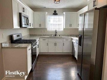 Mcdonough house for rent - a kitchen with white cabinets and a stainless steel refrigerator