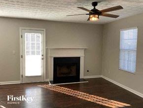 Mcdonough house for rent - a empty living room with a fireplace and a ceiling fan