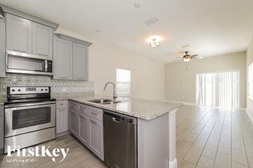 Kissimmee house for rent - a kitchen with stainless steel appliances and a granite counter top