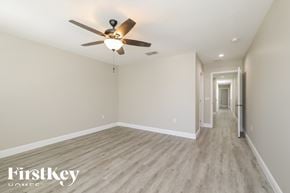 Kissimmee house for rent - a spacious living room with hardwood floors and a ceiling fan