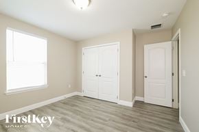 Kissimmee house for rent - a bedroom with two closets and a door and a window