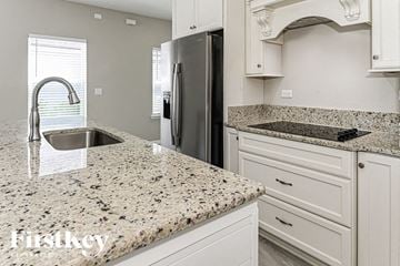 Fernandina Beach house for rent - a white kitchen with granite counter tops and a stainless steel refrigerator