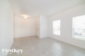 Davenport house for rent - A spacious, empty room with a door and a window.