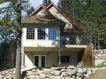 Rathdrum house for rent - a white house with rocks on the ground