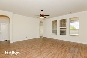 Aledo house for rent - an empty living room with a ceiling fan and wood floors