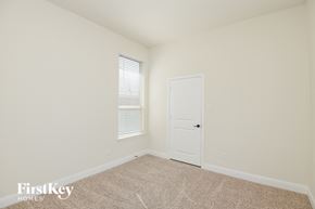 Aledo house for rent - a bedroom with a door and a window and a carpeted floor