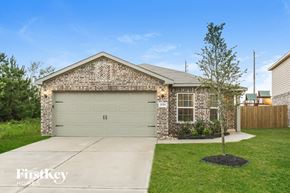 Hockley house for rent - A brick house with a garage door and a tree in the front yard.