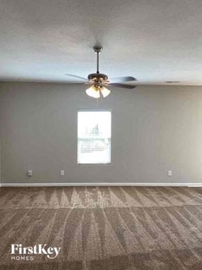 Charlotte house for rent - an empty living room with a ceiling fan and a window