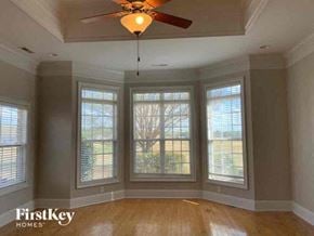 Hampton house for rent - a living room with a ceiling fan and four windows