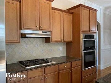 Hampton house for rent - a kitchen with wooden cabinets and a stove and oven