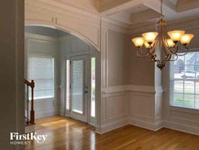 Hampton house for rent - a dining room with a chandelier and a door