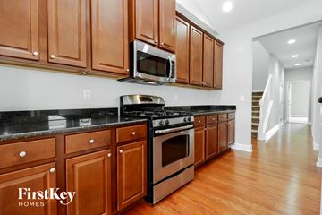 Summerville house for rent - A kitchen with wooden cabinets and a black countertop.