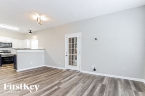 Gainesville house for rent - A spacious room with wooden flooring and a white door.