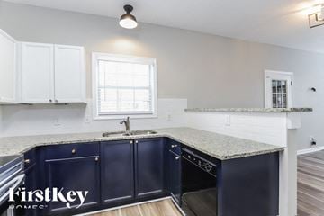 Gainesville house for rent - A kitchen with dark blue cabinets and a granite countertop.