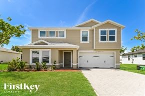 Cape Coral house for rent - a beige house with a garage and a lawn