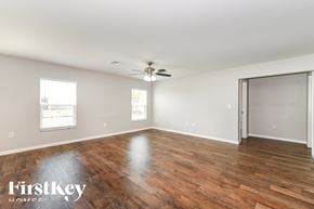 Cape Coral house for rent - an empty living room with wood floors and a ceiling fan