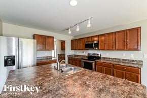 Cape Coral house for rent - a kitchen with granite counter tops and wooden cabinets