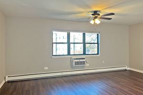 Forest Park apartment for rent - A room with a ceiling fan and a window with a view of a building outside.