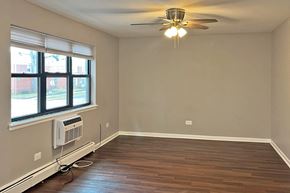 Forest Park apartment for rent - A room with a ceiling fan and a window with an air conditioner unit.