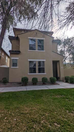 Mesa house for rent - A beige house with a black door and windows.