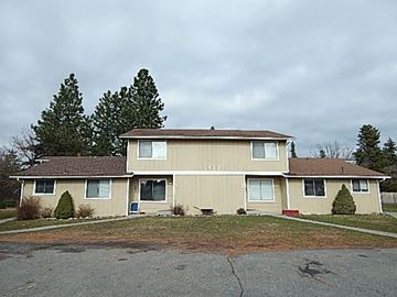 Coeur D' Alene house for rent - a beige house with a yard and trees