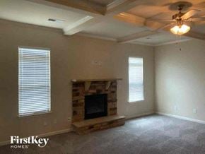 Conyers house for rent - a living room with a fireplace and a ceiling fan
