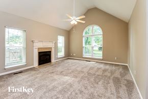 Mccalla house for rent - A spacious room with a fireplace and a ceiling fan.