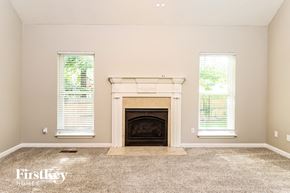 Mccalla house for rent - A living room with a fireplace and two windows.
