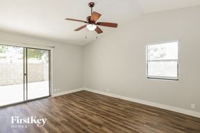 Phoenix house for rent - A room with a ceiling fan and sliding glass doors.