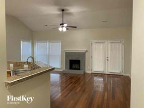 Indian Trail house for rent - an empty living room with a fireplace and a ceiling fan