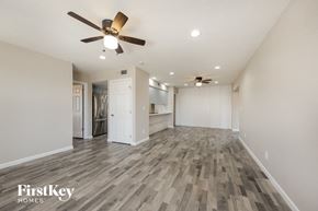 Glendale house for rent - A spacious room with a wood floor and a ceiling fan.