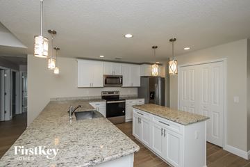 Palm Bay house for rent - a kitchen with white cabinets and granite counter tops